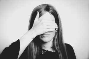 grayscale photo of woman covering her eyes